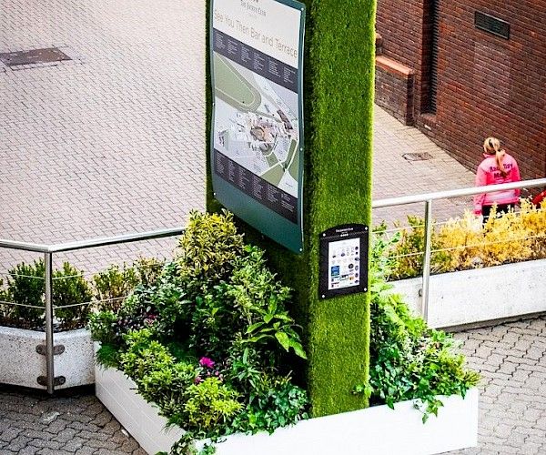 turf totem with directional map signage to front with planting to bottom