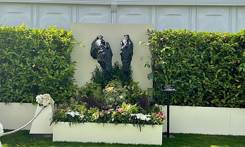 Royal Ascot statue with hedging and planted garden to front