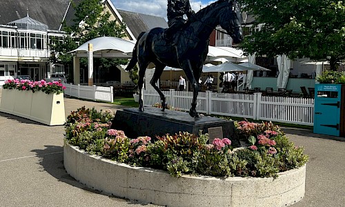 Royal Ascot statue with pink floral planting