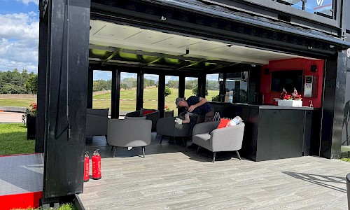Renault- Shipping Container Unit bottom floor with grey furniture and bar