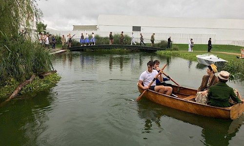 Goodwood Revival built lake and boat house people rowing on the river
